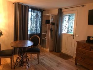 sala de estar con mesa y ventana en Casa la Rosa & Spa, en Courdimanche-sur-Essonnes