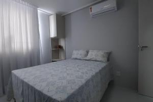 - une petite chambre avec un lit et une couette blanche dans l'établissement Ed. Manoel Cordeiro - Stúdio Meu aconchego II, à Caruaru
