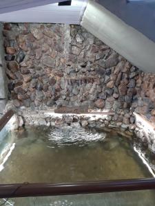 a pool of water next to a stone wall at Pousada Centaurus in Alto Paraíso de Goiás