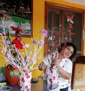 Une femme fait un vase avec des fleurs. dans l'établissement Casa Palagui Colonial, à Valladolid