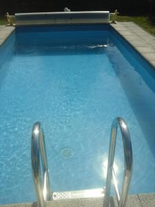 a blue swimming pool with two metal rails in it at Appartment Andrea in Eugendorf