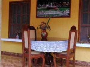 - une table à manger avec des chaises et un vase dans l'établissement Casa Palagui Colonial, à Valladolid