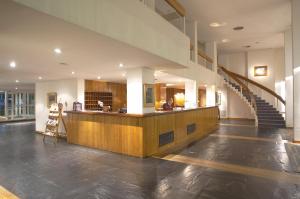 a lobby with a staircase and a counter in a building at Hotel Libertador in Tandil