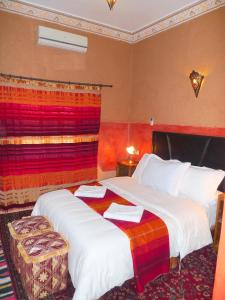 Habitación de hotel con 2 camas y toallas. en Maison d'Hôtes Nouflla, en Aït Ben Haddou