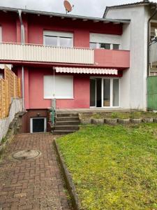 a red and white house with a lawn in front of it at Tokis Feriendomizil 2.0 in Bad Säckingen