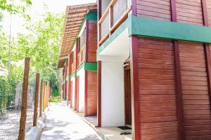 eine Reihe von Gebäuden mit Holztüren auf einer Straße in der Unterkunft Campos Elísios Boipeba in Ilha de Boipeba