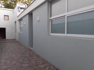 un pasillo de un edificio blanco con ventana en Bello Jazmin 2 en San Rafael