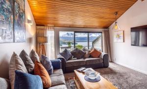a living room with a couch and a table at Distinctive Alpine Meadows in Queenstown