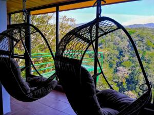 two hanging hammocks in a room with a view at Rainbow Valley Lodge Costa Rica in Monteverde Costa Rica