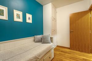 a bedroom with a bed with a blue wall at Dejana Apartment in Zlatibor