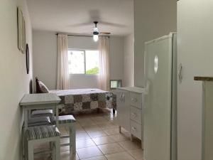 um quarto com um frigorífico, uma mesa e uma janela em Joneson aluga QUITINETE próximo a Praia do Forte até 4 pessoas em Cabo Frio