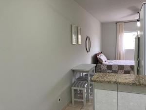 a small room with a bed and a desk in it at Joneson aluga QUITINETE próximo a Praia do Forte até 4 pessoas in Cabo Frio +64 photos