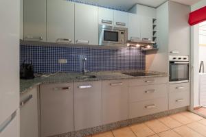 eine Küche mit weißen Schränken und einem Waschbecken in der Unterkunft Casas-VeraPlaya Al Andalus Residencial Casa La Libertad in Vera