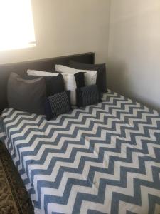 Cama con sábanas y almohadas azules y blancas en Cozy Mother-in-Law Suite, en Norfolk