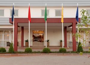 eine Gruppe von Flaggen vor einem Gebäude in der Unterkunft Imigrantes Hotel in Santa Rosa