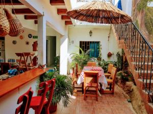 une terrasse avec une table, des chaises et un parasol dans l'établissement Hostal Solsticio Guajiro, à Ríohacha