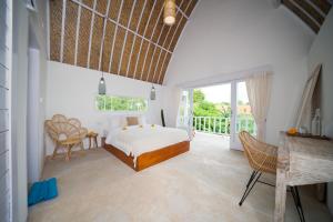1 dormitorio con 1 cama y balcón en Kelana Uluwatu en Uluwatu