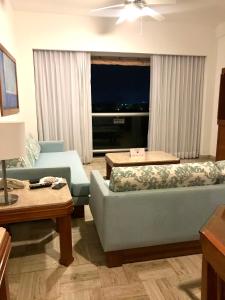 uma sala de estar com dois sofás azuis e uma janela em Vidanta Sea Garden Nuevo Vallarta em Nuevo Vallarta
