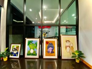 un groupe d'images sur une étagère dans une fenêtre dans l'établissement The Vet Boutique Hotel - SHA Extra Plus, à San Kamphaeng