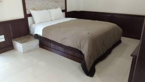 1 dormitorio con 1 cama grande y cabecero de madera en Northstar Hotel & Resort, en Ban Mae Kon
