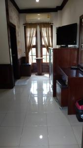 sala de estar con TV y suelo de baldosa blanca en Northstar Hotel & Resort, en Ban Mae Kon