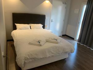 una camera da letto con un letto bianco con due asciugamani di Midway Motel - Richmond a Richmond