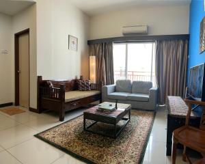 マラッカにあるHomestay 3 rooms suite Apartment 8-10pax at Amari Villa Bukit Katil, Ayer Keroh Melakaのリビングルーム(ソファ、テーブル付)