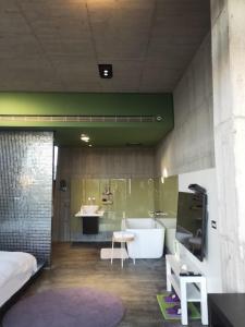een badkamer met een bad, een wastafel en een bed bij Water with Candle Homestay in Wujie