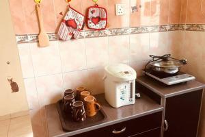 Tambun homestay في ايبوه: طاولة مطبخ مع محمصة وأكواب عليها