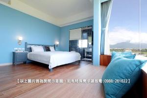 a bedroom with a white bed and blue walls at Zen Ocean in Jian