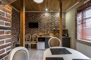 uma cozinha com cadeiras e uma parede de tijolos em Hotel Family em Pskov