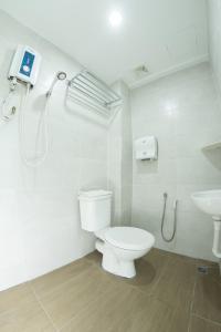 a bathroom with a toilet and a sink at Grand Bagan Hotel in Butterworth