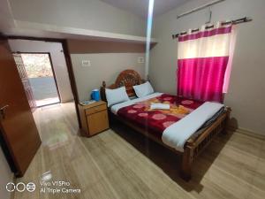 um quarto com uma cama e uma cortina rosa em GK Holidays em Ooty