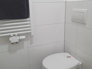 a bathroom with a white toilet and a toilet paper dispenser at Apartment Flora three in Duisburg
