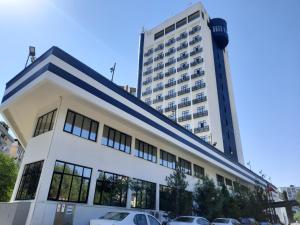 a large white building with cars parked in front of it at Plaza Hotel Diyarbakir in Diyarbakır