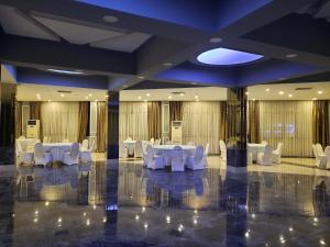 a banquet hall with white tables and white chairs at Plaza Hotel Diyarbakir in Diyarbakır