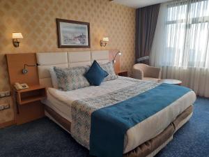 a hotel room with a large bed and a chair at Plaza Hotel Diyarbakir in Diyarbakır +21 photos