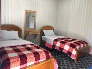 a hotel room with two beds and a mirror at Madina Hotel 2 in Gilgit