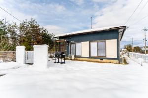 a small house on top of a snow covered yard at Takashima Lakeside Resort in Takashima