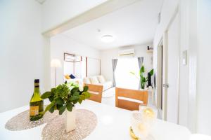 a dining room with a white table with a bottle of wine at Takashima Lakeside Resort in Takashima