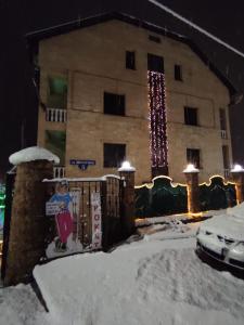 a building with a fence in the snow at Utomlyonnye Solntsem Hotel in Krasnaya Polyana
