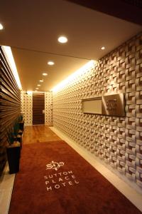 東京的住宿－Sutton Place Hotel Ueno，走廊上铺有红地毯,墙壁上配有电视