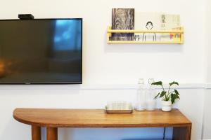 a flat screen tv sitting on top of a wooden table at OwlStay The Salt in Hualien City