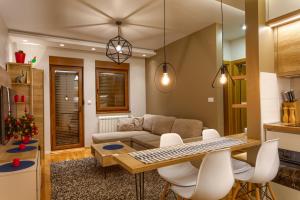 a living room with a couch and a table and chairs at Dejana Apartment in Zlatibor