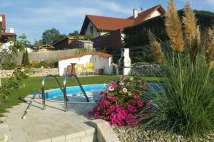 a swimming pool in a yard with pink flowers at Villa Casa sol-rural residence near Linz in Katsdorf