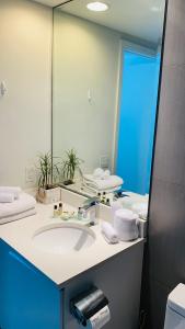 baño con lavabo y espejo grande en Monte Carlo by Miami Ambassadors, en Miami Beach