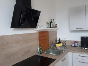 a kitchen with a sink and a tv on the wall at An der Stadtmauer in Halberstadt