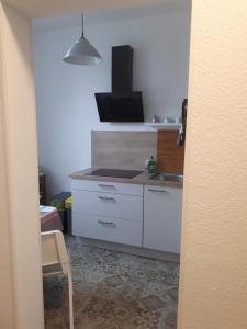 a kitchen with white cabinets and a sink at An der Stadtmauer in Halberstadt +1 photo