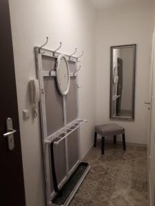 a bathroom with a mirror and a clock on the wall at An der Stadtmauer in Halberstadt