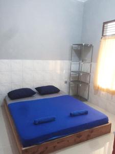 a blue bed with two pillows in a room at Abimanyu Notoprajan in Ngabean